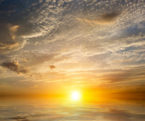 Colorful sea sunset with uniform multicolored clouds.