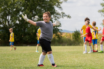 Obraz premium Kids soccer - Little goalkeeper is celebrating after successful football match