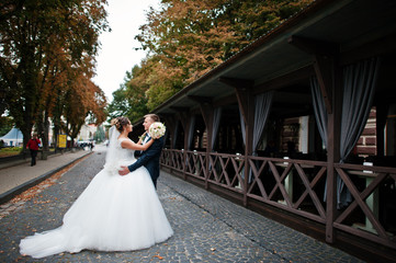 Romantic newly married wedding couple hugging on the street of an old town on an urban background...