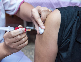soft focus,nurses are vaccinations to patients using the syringe.Doctor vaccinating women in...