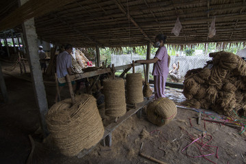 BEN TRE, VIETNAM - JUNE 19, 2016 - Vietnamese male spin coconut fiber to make material for coir mat, a tradition product from coconut at spinning coir traditional village, Bentre, Vietnam