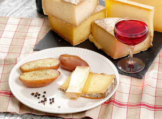 Different french cheeses with a glass of wine