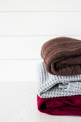 A stack of autumn sweaters on a white background