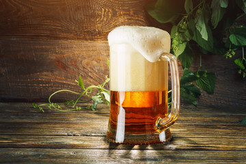 A glass of fresh beer on a wooden table.