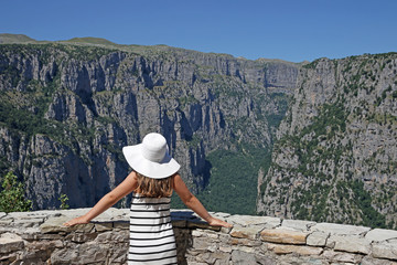 Fototapeta na wymiar girl with white hat on the viewpoint Vikos gorge Greece