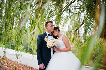 Good-looking newly married couple walking and enjoying each other's company in the park on a bright...