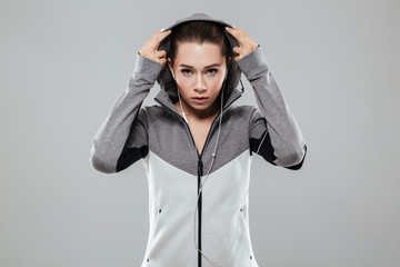 Attractive woman putting on her hood and looking at camera