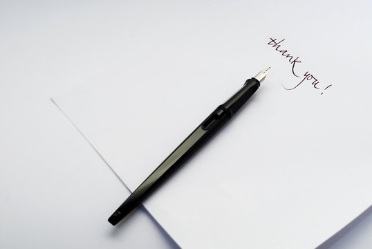 Penna stilografica su foglio bianco con la scritta "thank you"