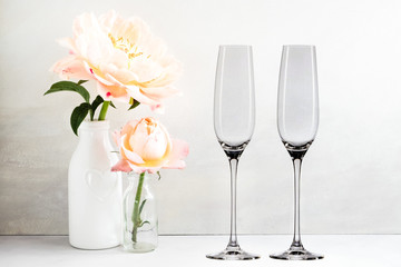 Floral Mockup - 2 empty champagne glasses, next to flower arrangement, perfect for businesses who...
