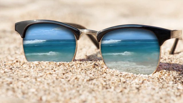 Cinemagraph - Sunglasses on the sand. Motion Photo.