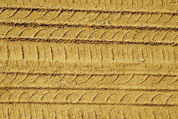 Automobile tire tracks on sandy road.