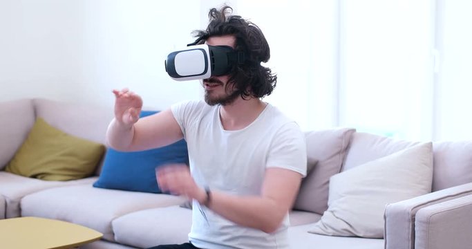 Man with afro hair using VR headset at sofa