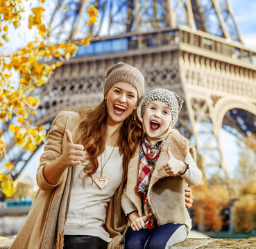 mother and child travellers in Paris, France showing thumbs up