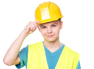 Emotional portrait of handsome teen boy wearing safety jacket and yellow hard hat. Happy child looking at camera, isolated on white background. Funny cute guy - construction worker or architect.