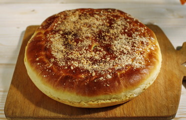 Ruddy baked onion and eggs pie on wooden table close up