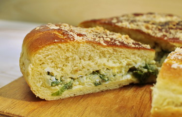 Ruddy baked onion and eggs pie on wooden table close up