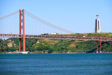 25th of April Bridge suspension bridge over river Tejo with Jesus Christ the King Statue on background in Lisbon. Portugal