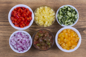 Assortment of vegetables sliced. Peppers, tomatoes, cucumber and onion in bowls