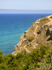 Fototapeta na wymiar Dangerous hiking path on a cliff near the ocean in Sintra, Portugal