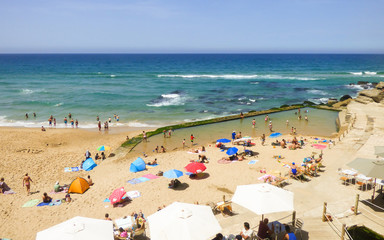 Azenhas do Mar, Portugal - circa August 2017: People in a sunny summer day enjoying the beach of Azenhas do Mar in Colares region (Sintra, Portugal)