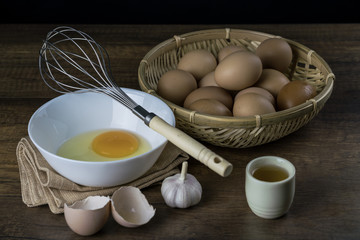egg in the basket and whisk with garlic and Japanese green tea on wood background