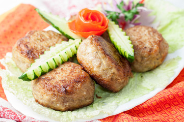 Beef cutlets with greens and vegetables on the plate