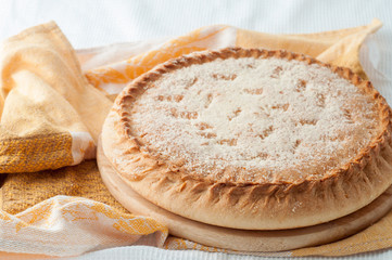 round pie with filling on a table