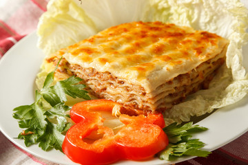 lasagne with meat and tomato on the plate