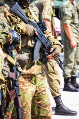 Fototapeta premium Soft focus. Soldier in camouflage holding a finger on the trigger of a Kalashnikov