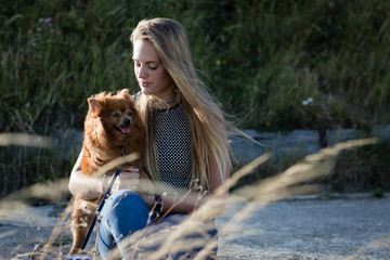 Young Female cuddling her pet dog in countryside