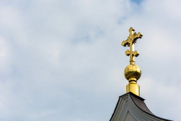 Fototapeta na wymiar Golden cross on a small Golden dome.