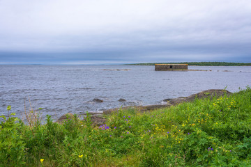 Landscape with a lone stone building on a small island.