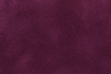 Background of dark purple suede fabric closeup. Velvet matt texture of wine nubuck textile