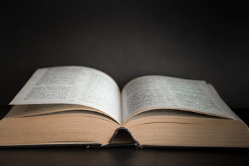 Obraz premium Opened bible in the quiet, dark atmosphere. Prayer time on sunday.