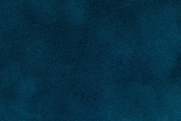 Background of dark blue suede fabric closeup. Velvet matt texture of navy blue nubuck textile