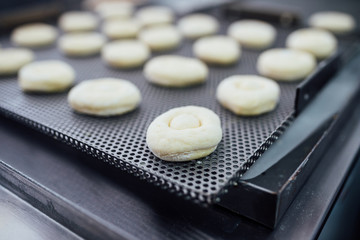 Procedure of making donuts in a small town donut bakery. Selective focus.