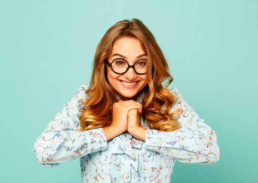Pretty smiley girl wearing glasses over blue background