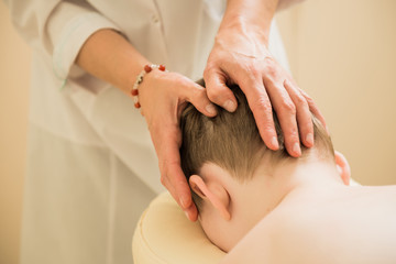Fototapeta na wymiar therapist making massage on boy head