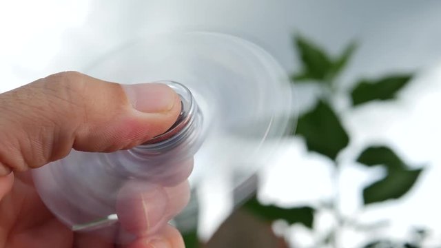 Hand holding popular fidget spinner toy on sky background 