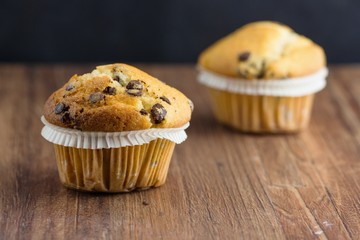 Two chocolate chips vanilla flavor muffins. Selective focus on the front one.