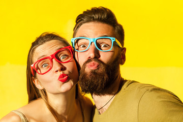 Freckled woman, and bearded man send air kissing at camera