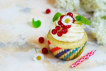 Gentle cupcake with cream and berries аnd a candle a light background