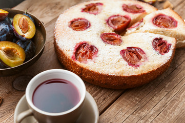Pie with plum. In rustic style on a wooden surface