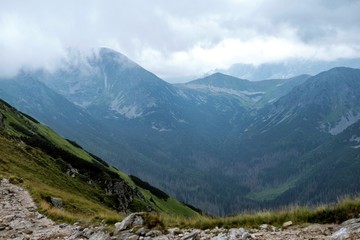 Mountain path. Peaks of mountains in the clouds.