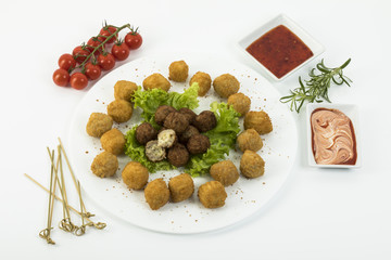 Hackfleischbällchen mit frittierten Kartoffelkugeln auf weissem Hintergrund