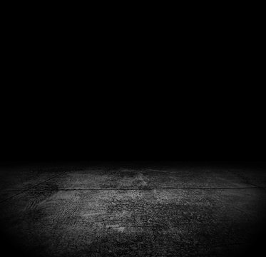 An empty grunge cement floor in the dark for horror or scary background