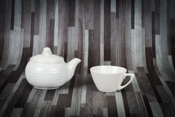 white tea pot and cup on wood