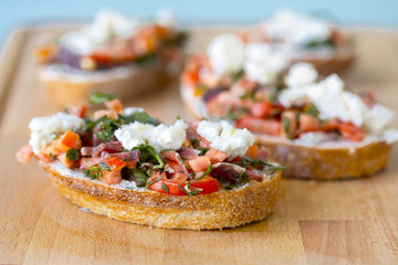 Bruschetta with tomato, cheese and olive oil on a blue background