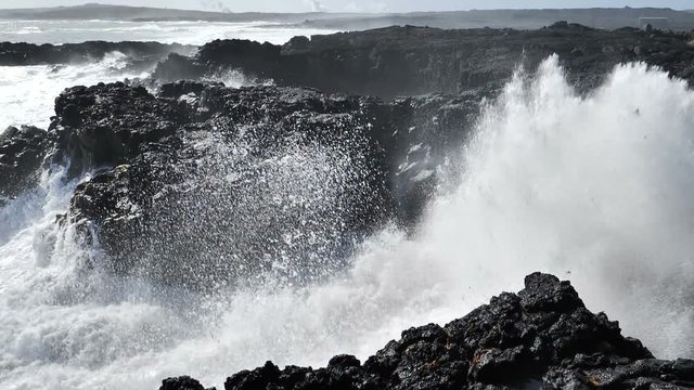 Powerful waves crashing on lava rock slow motion close up Reykjanes Iceland