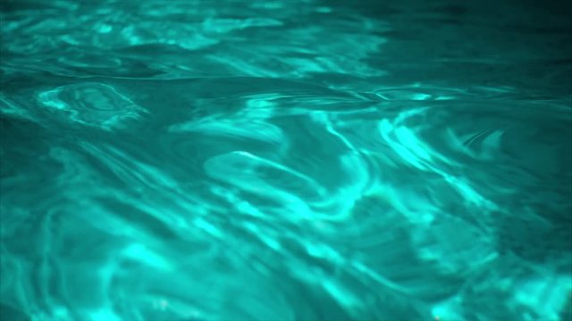Ripple turquoise water in swimming pool with sun reflection
